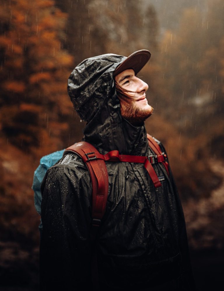 Ein Wanderer im Regen mit Regenjacke.