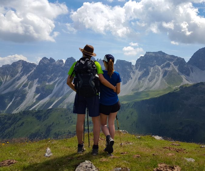 EIn Pärchen schaut auf eine Bergkette.